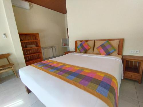 sypialnia z łóżkiem z kolorowym kocem w obiekcie Meme Lan Bape Guest House w mieście Ubud