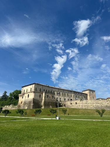 a large building on a hill with a green field at Relais Della Corte in Sala Baganza