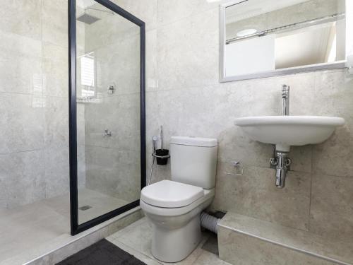 a bathroom with a toilet and a sink and a shower at Camdale Guesthouse in Cape Town