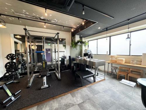 a room with a gym with weights and a table at Time Camp 高輪 in Tokyo