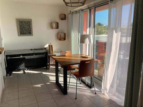 une salle à manger avec une table et un piano dans l'établissement Studio proche gare et jardin des plantes, à Nantes