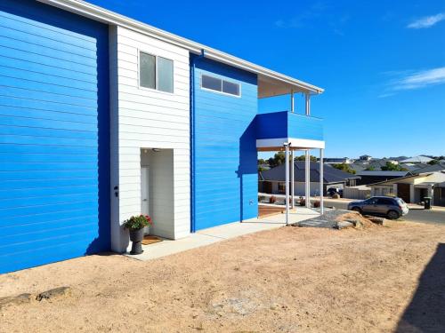 a blue and white building with a driveway at Azure Haven Holiday Home in Port Hughes