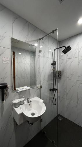 a bathroom with a sink and a mirror at d'primahotel Harmoni Jakarta - Hayam Wuruk in Jakarta