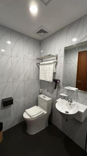 a bathroom with a toilet and a sink at d'primahotel Harmoni Jakarta - Hayam Wuruk in Jakarta