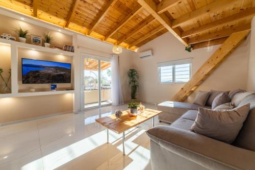 a living room with a couch and a table at RELAXING POOL HOUSE IN LAGONISI 1 in Kalívia Thorikoú