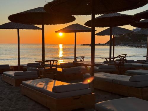 a group of chairs and umbrellas on the beach at Blue Harmony Hotel in Kinion