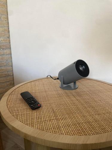 a remote control sitting on top of a wooden table at Le Clos du Léman I Charme & Sauna in Anthy