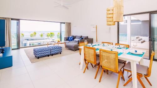 a dining room and living room with a table and chairs at Latitude By Horizon Holidays in Rivière Noire
