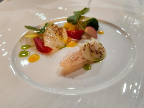 a white plate with some food on a table at Pension Green Lake in Gujo