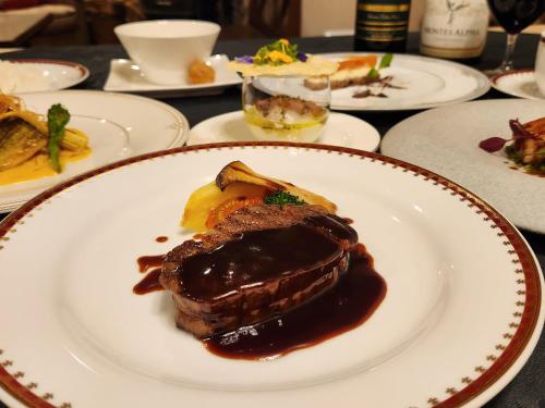 a plate of steak with sauce on a table at Pension Green Lake in Gujo