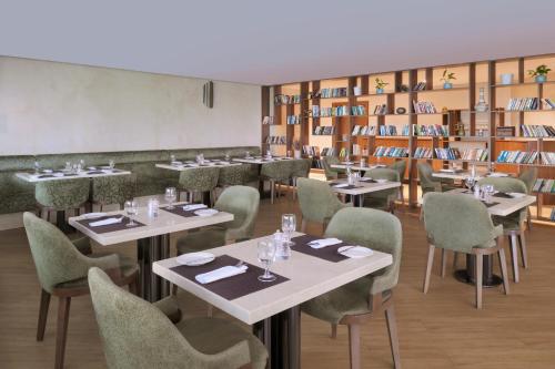 ein Restaurant mit Tischen, Stühlen und Büchern in der Unterkunft Mövenpick Hotel Apartments Downtown Dubai in Dubai