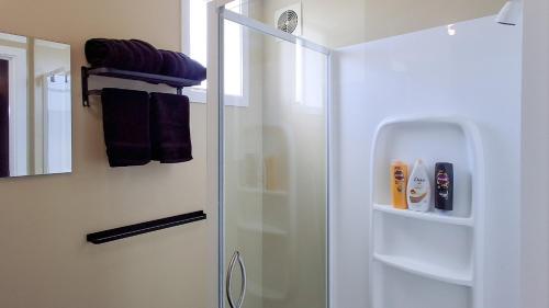a bathroom with a shower with a glass door at Blue Mountains Loft, Tapanui in Glenkenich