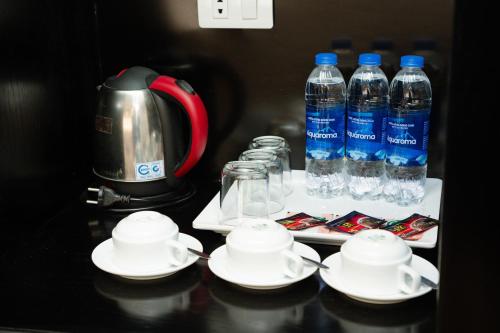 a table with cups and plates and bottles of water at MT Collection Hotel Ha Long in Ha Long