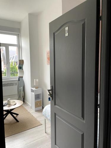 une porte ouverte menant à une chambre avec une table dans l'établissement Lumineux & Chic sur Villars, à Valenciennes