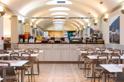a restaurant with tables and chairs and a buffet at Crystal Hotel Varese in Varese