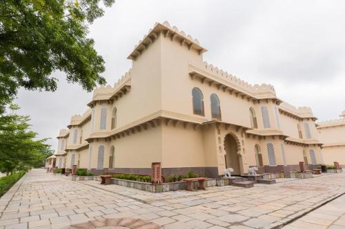 a large white building with a courtyard in front at Kesar Bagh Palace Chittorgarh in Chittaurgarh