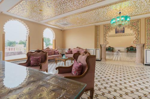 a lobby with chairs and a table and a chandelier at Kesar Bagh Palace Chittorgarh in Chittaurgarh