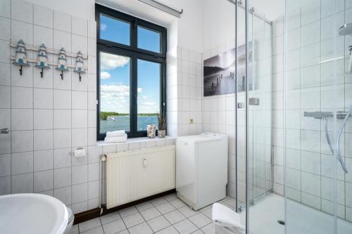 a bathroom with a shower and a toilet and a sink at SeaLove - Gemütliches Apartment mit Seeblick am Malchower See in Malchow