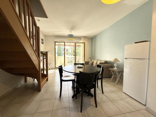une cuisine et une salle à manger avec une table et un réfrigérateur dans l'établissement résidence avec piscines à proximité de Gordes, à Gordes