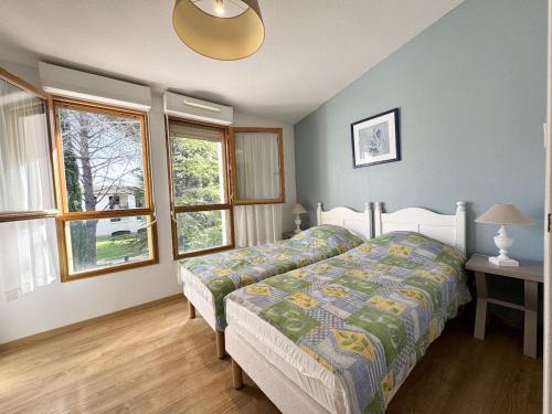 une chambre avec un lit et deux fenêtres dans l'établissement résidence avec piscines à proximité de Gordes, à Gordes