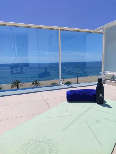 a room with a blue pillow on a table with a view of the ocean at Hotel Calella by Beatriz Hoteles in Calella