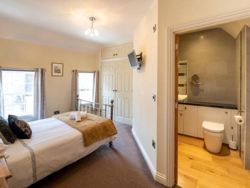 una camera da letto con un letto grande e una televisione di Pass the Keys Bright and cosy flat in the centre of Much Wenlock a Much Wenlock