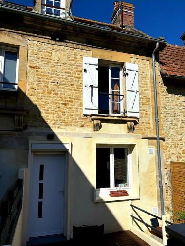 - un bâtiment en briques avec des fenêtres blanches et une porte dans l'établissement Maison terrasse proche mer, à Douvres-la-Délivrande