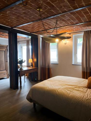 a bedroom with a bed and a table and windows at Le Zucche Vuote in Quargnento
