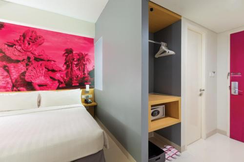 a bedroom with a white bed and a pink painting at favehotel Solo Baru in Solo