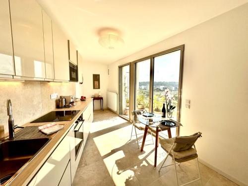une cuisine avec une table et une grande fenêtre dans l'établissement Duplex Avec Terrasse Dans Le Ciel Bordelais, à Bordeaux