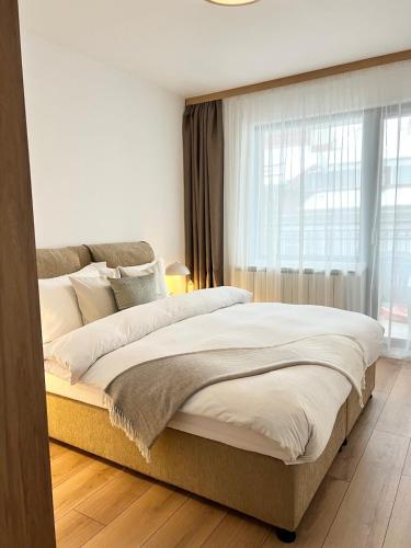 a large bed in a bedroom with a large window at Comfort Modern Central Apt in Haskovo