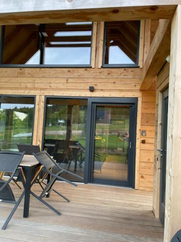 a house with glass doors and a table on a deck at Rezidence Cedrinum in Bublava
