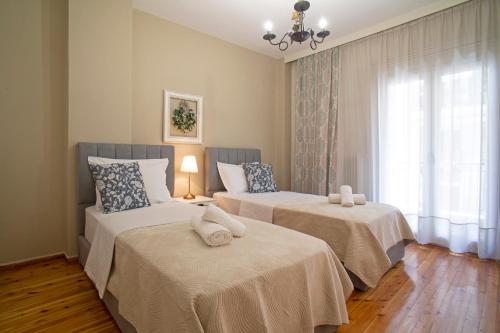 a bedroom with two beds and a window at Cozyhome 4 ILISIA in Thessaloniki