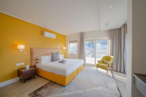 a hotel room with a bed and a chair at One Marine Drive Boutique Hotel & Spa by The Living Journey Collection in Hermanus