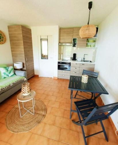 un salon avec une table et des chaises et une cuisine dans l'établissement Appartement terrasse vue mer, à Sainte-Maxime