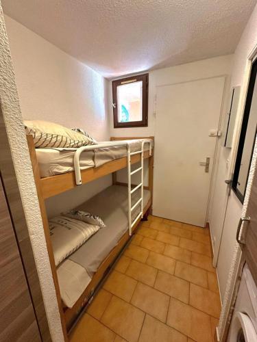 Cette petite chambre comprend des lits superposés et une porte. dans l'établissement Appartement terrasse vue mer, à Sainte-Maxime