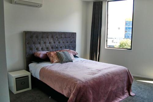 a bedroom with a large bed with a window at Modern City Loft, 2BR Split, 2 Levels & Parking in Auckland