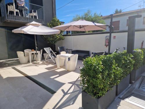 a patio with tables and chairs and an umbrella at San Marco Holidays in Lucca