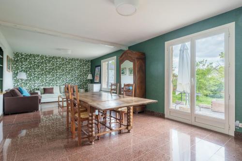 une salle à manger avec des murs verts et une table en bois dans l'établissement La Maison et son jardin sur le Canal de Bourgogne, à Ravières