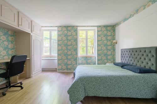 a bedroom with a bed and a chair and windows at La Maison et son jardin sur le Canal de Bourgogne in Ravières