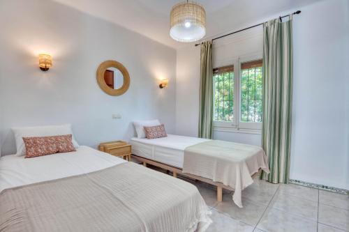 Un dormitorio con dos camas y una ventana. en Escale, en Pals