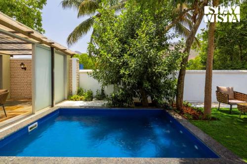 a swimming pool in the backyard of a house at StayVista at The Five Oaks - Private Pool Cottages in Karjat