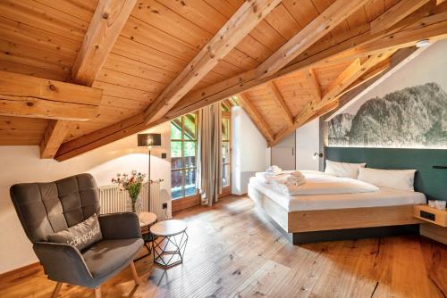 a bedroom with a bed and a chair in a room at Ferienwohnung Falkenstein in Inzell