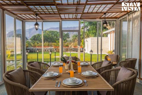 a dining room with a wooden table and chairs at StayVista at The Five Oaks - Private Pool Cottages in Karjat