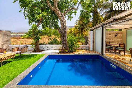 a swimming pool in the backyard of a house at StayVista at The Five Oaks - Private Pool Cottages in Karjat