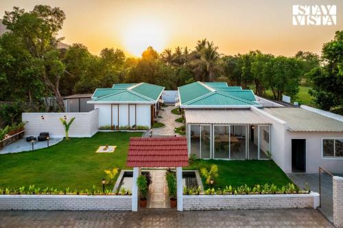 an aerial view of a house with a yard at StayVista at The Five Oaks - Private Pool Cottages in Karjat