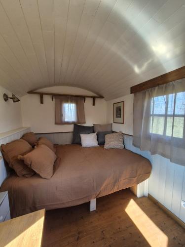 - un grand lit dans une chambre avec plafond dans l'établissement Les trois bergers, à Serley