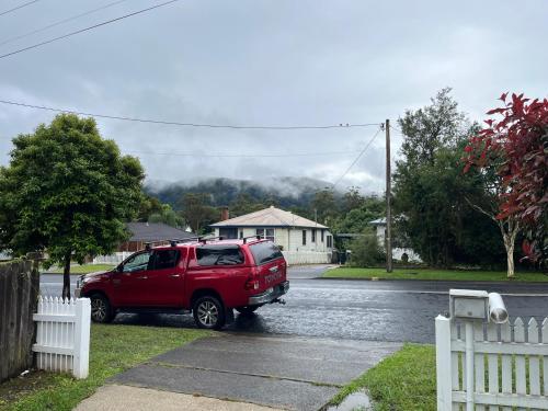 a red suv parked on the side of a street at Beryls House in Coffs Harbour