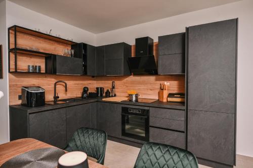 a kitchen with black cabinets and a table and chairs at Petra Hills Majestic in Opatija