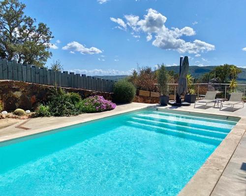 une piscine dans une cour clôturée dans l'établissement VILLA CARAMONTINU SERENA à Pinarello, proche plage, vue mer, piscine chauffée, à Zonza